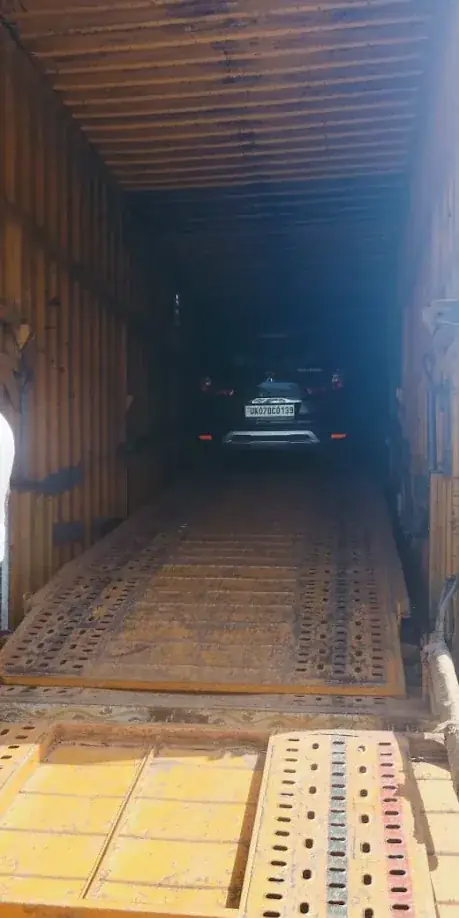 Car secured inside a closed carrier truck before leaving Dehradun