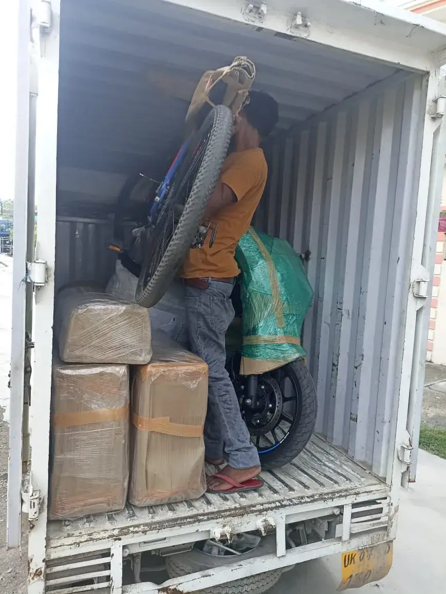 Movers loading wrapped household furniture into a truck during a house shift